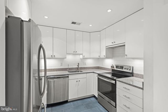 a bathroom with a granite countertop toilet sink and mirror