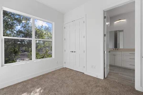 an empty room with windows and closet