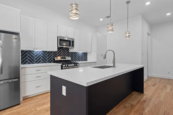 a kitchen with a sink dishwasher a stove and a refrigerator