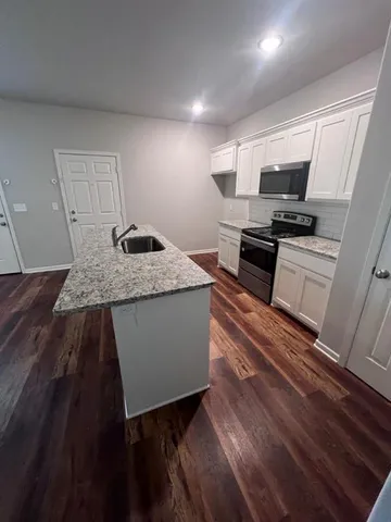 a living room with hard wood floors and a bed