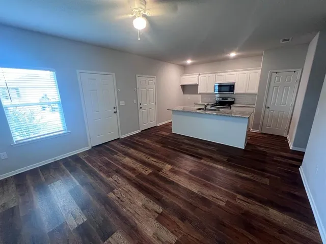 a large white kitchen with kitchen island a stove a sink and a refrigerator