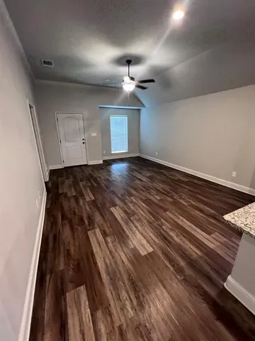 a view of a living room hardwood floor and a kitchen