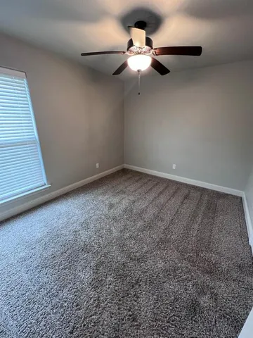 a view of an empty room with a chandelier fan