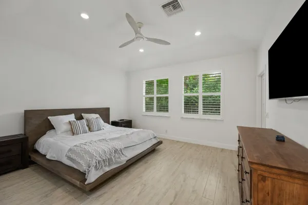 a bedroom with a large bed and a flat screen tv