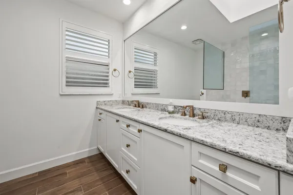 a bathroom with a granite countertop sink and a large mirror