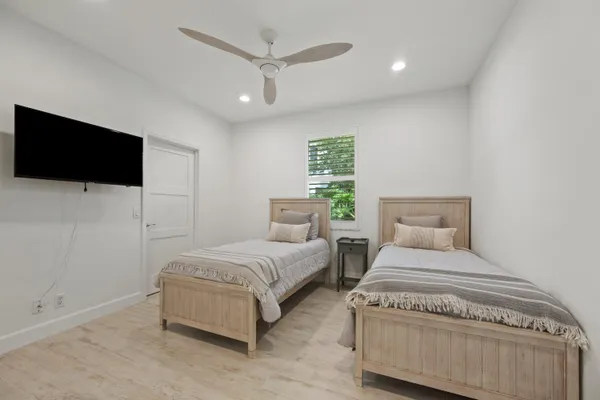 a spacious bedroom with a bed and a flat screen tv