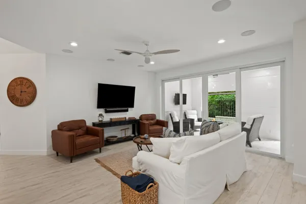 a living room with furniture ceiling fan and a large window