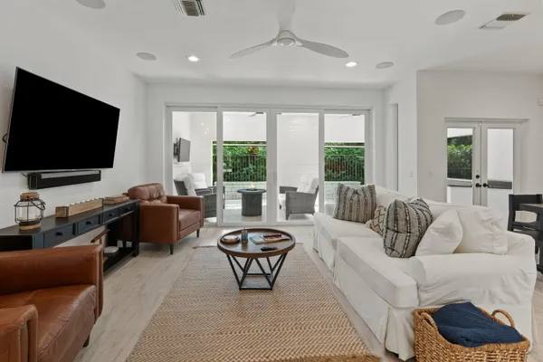 a living room with furniture a flat screen tv and a large window