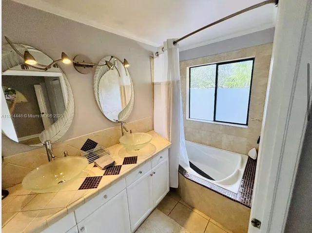 a bathroom with a tub sink and mirror