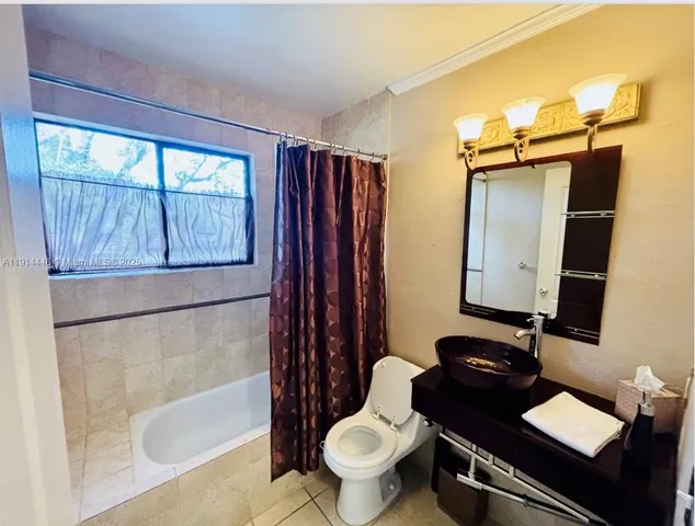 a bathroom with a granite countertop toilet sink and mirror
