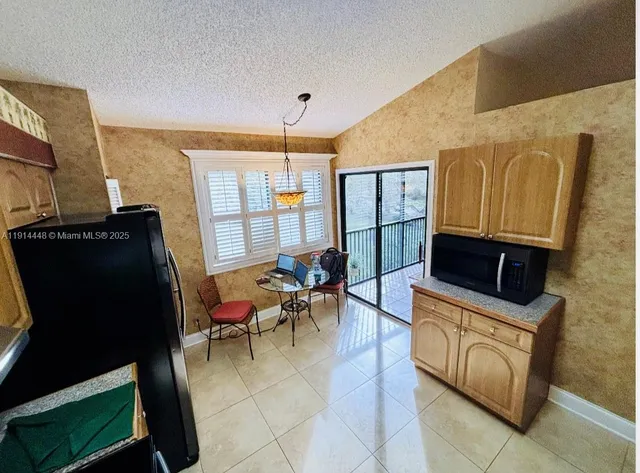 a living room with furniture a flat screen tv and a refrigerator