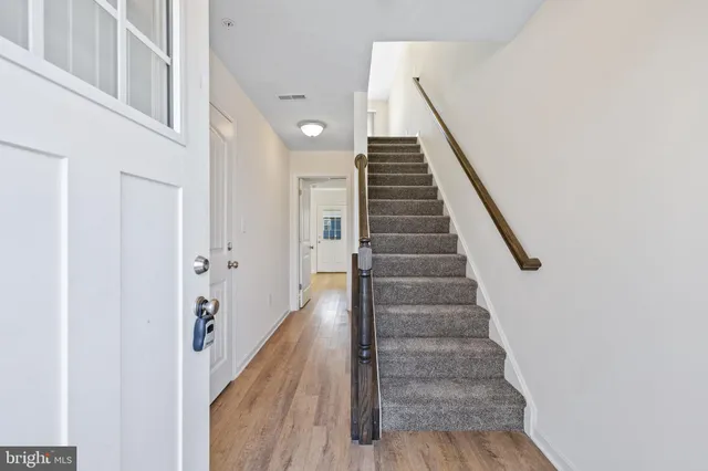 a view of a hallway with wooden floor and entryway