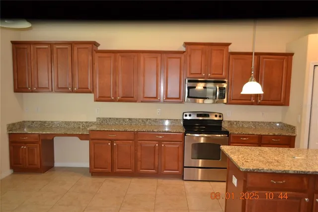 a kitchen with stainless steel appliances granite countertop a stove a sink dishwasher and microwave