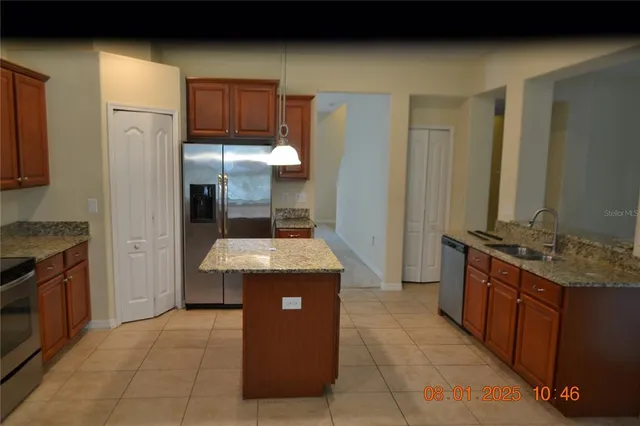 a kitchen with stainless steel appliances granite countertop a stove a refrigerator and a oven