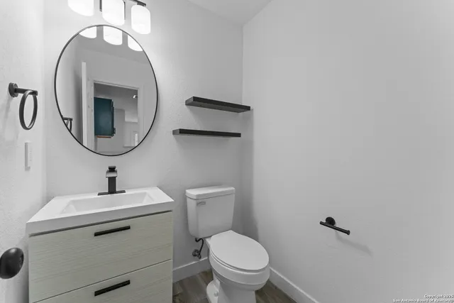 a bathroom with a toilet a sink and mirror