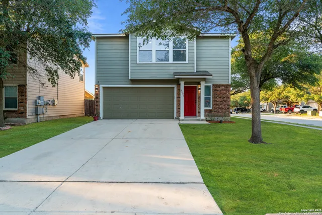 a front view of a house with a yard and trees