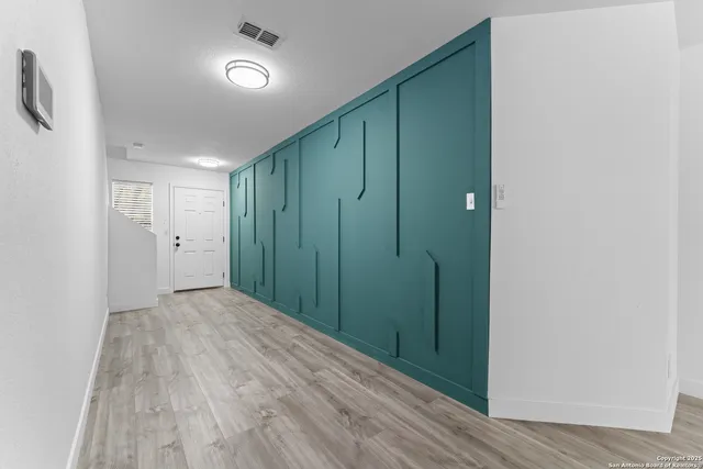 a view of an empty room with closet and a window