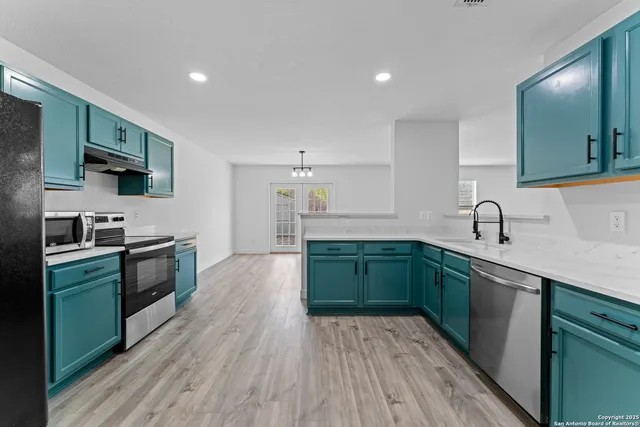 a kitchen with sink a microwave and cabinets