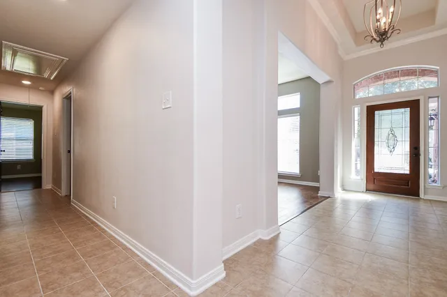 a view of a hallway with wooden floor and a living room
