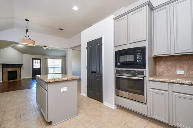 a kitchen with granite countertop a stove oven and sink