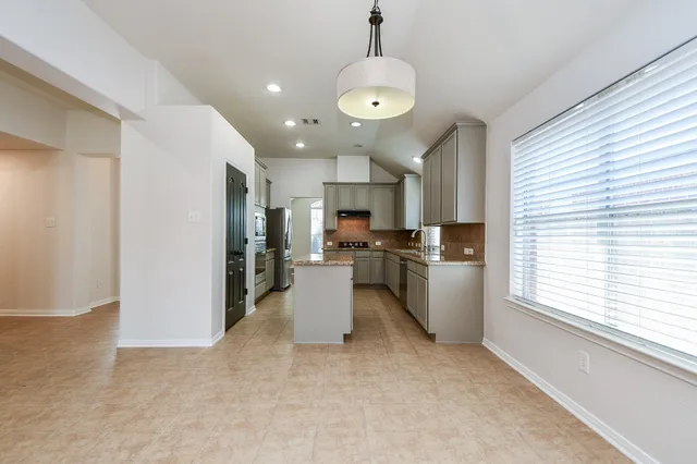 a view of a kitchen with stove and cabinets