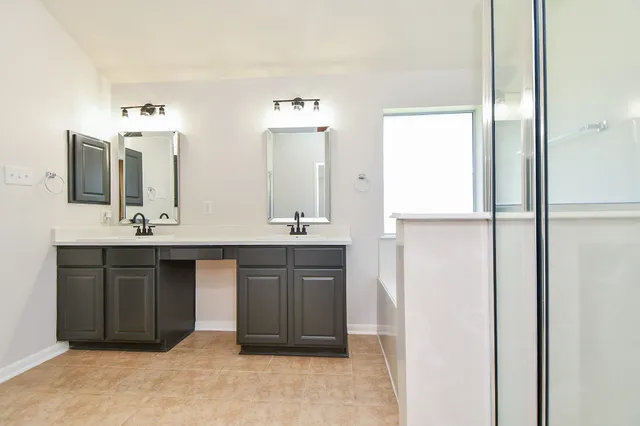 a bathroom with a double vanity sink and a mirror