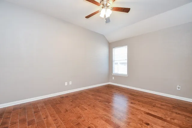an empty room with a window and a fan