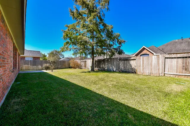 a view of a backyard with a garden and tree