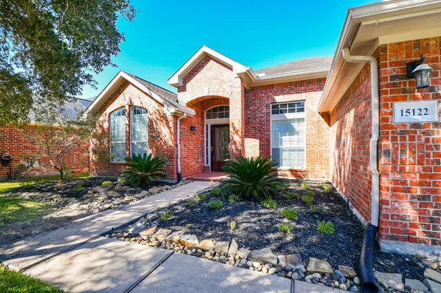 a front view of a house with plants and entryway