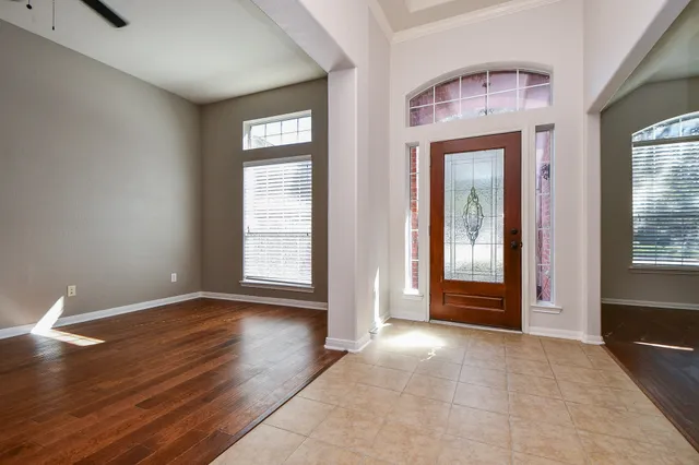 a view of an empty room with glass door and a window