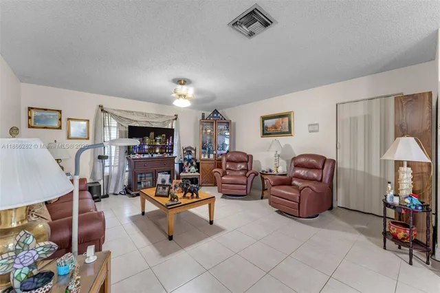 a living room with furniture and a dining table with kitchen view