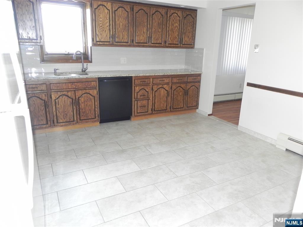 52 Wilson Street, Unit 2 Little Ferry, NJ 07643 - Photo 5 of 11 a kitchen with stainless steel appliances granite countertop a stove a sink and a refrigerator