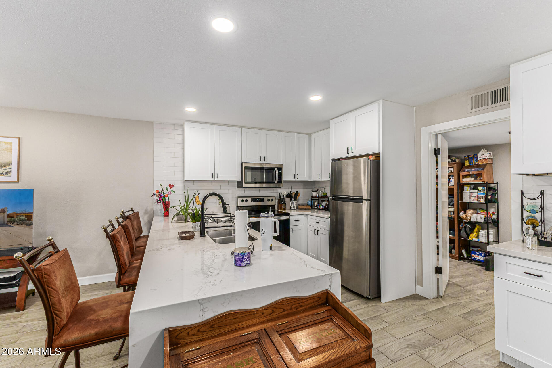 847 West Rice Drive Tempe, AZ 85283 - Photo 12 of 40 a kitchen with stainless steel appliances kitchen island granite countertop a refrigerator a stove a sink a dining table and chairs