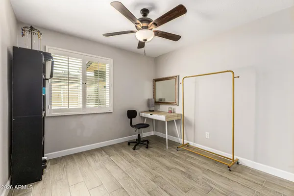a work room with wooden floor and a ceiling fan