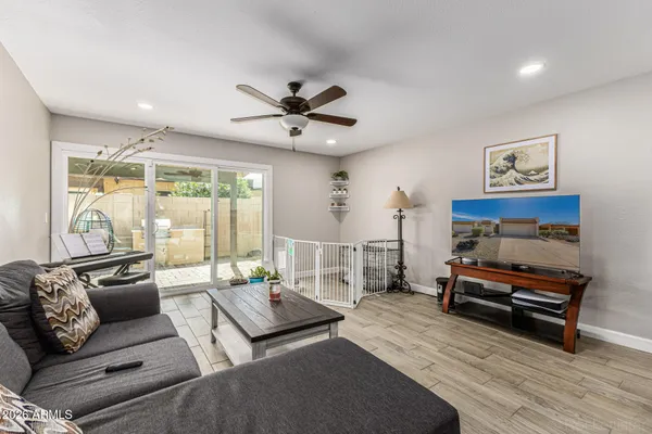 a living room with furniture a wooden floor and a large window
