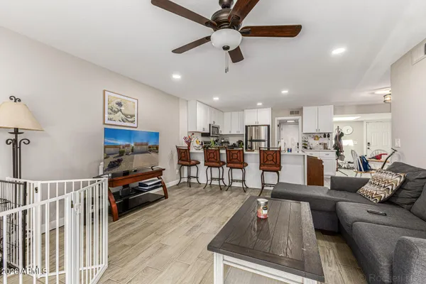 a living room with furniture kitchen view and a flat screen tv
