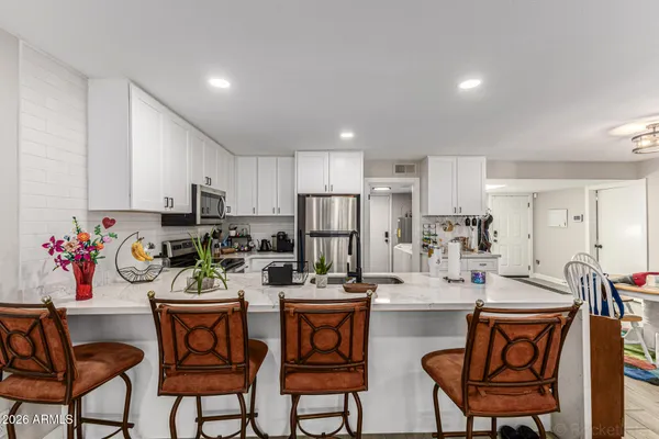 a kitchen with stainless steel appliances kitchen island granite countertop a refrigerator and microwave