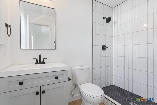 a bathroom with a sink a toilet and shower