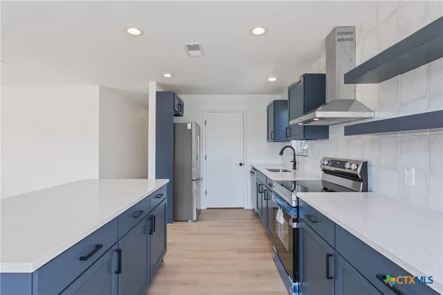 a kitchen with stainless steel appliances a sink stove and refrigerator