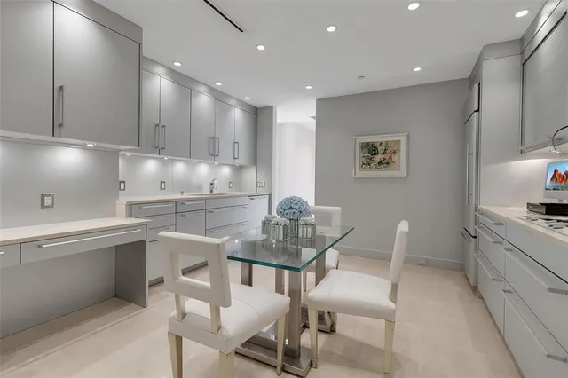 a kitchen with granite countertop white cabinets and chairs