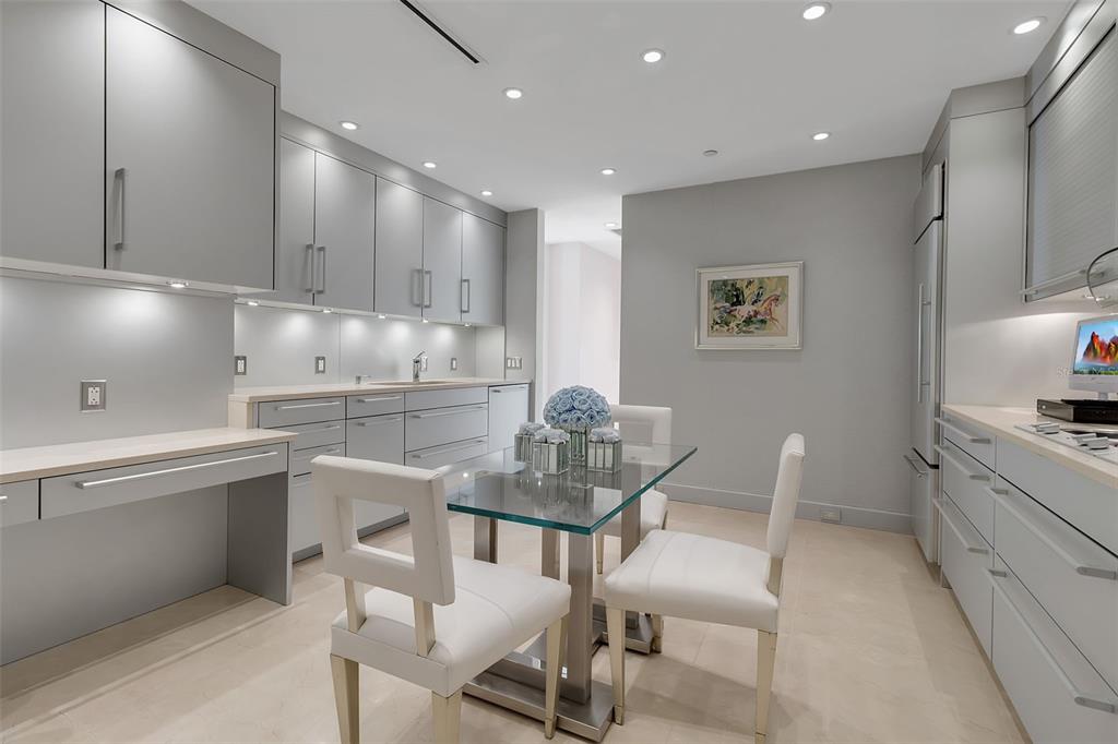 1111 Ritz Carlton Drive, Unit 1202 Sarasota, FL 34236 - Photo 21 of 49 a kitchen with granite countertop white cabinets and chairs