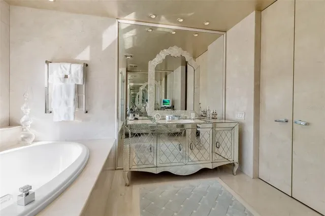 a bathroom with a tub sink and mirror