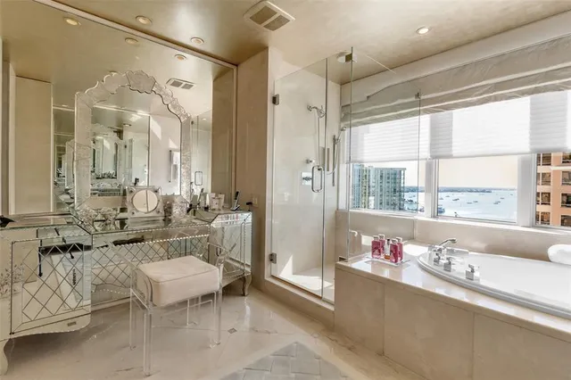 a bathroom with a granite countertop sink mirror and a bathtub