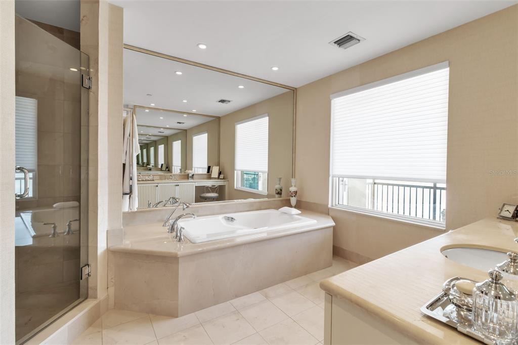 1111 Ritz Carlton Drive, Unit 1202 Sarasota, FL 34236 - Photo 35 of 49 a large white bathroom with a large tub and sink