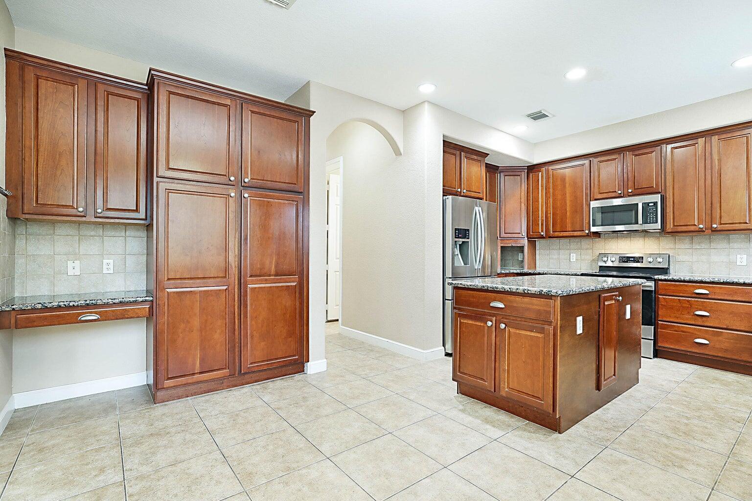748 Cresta Circle West Palm Beach, FL 33413 - Photo 22 of 62 a kitchen with stainless steel appliances granite countertop a refrigerator and cabinets