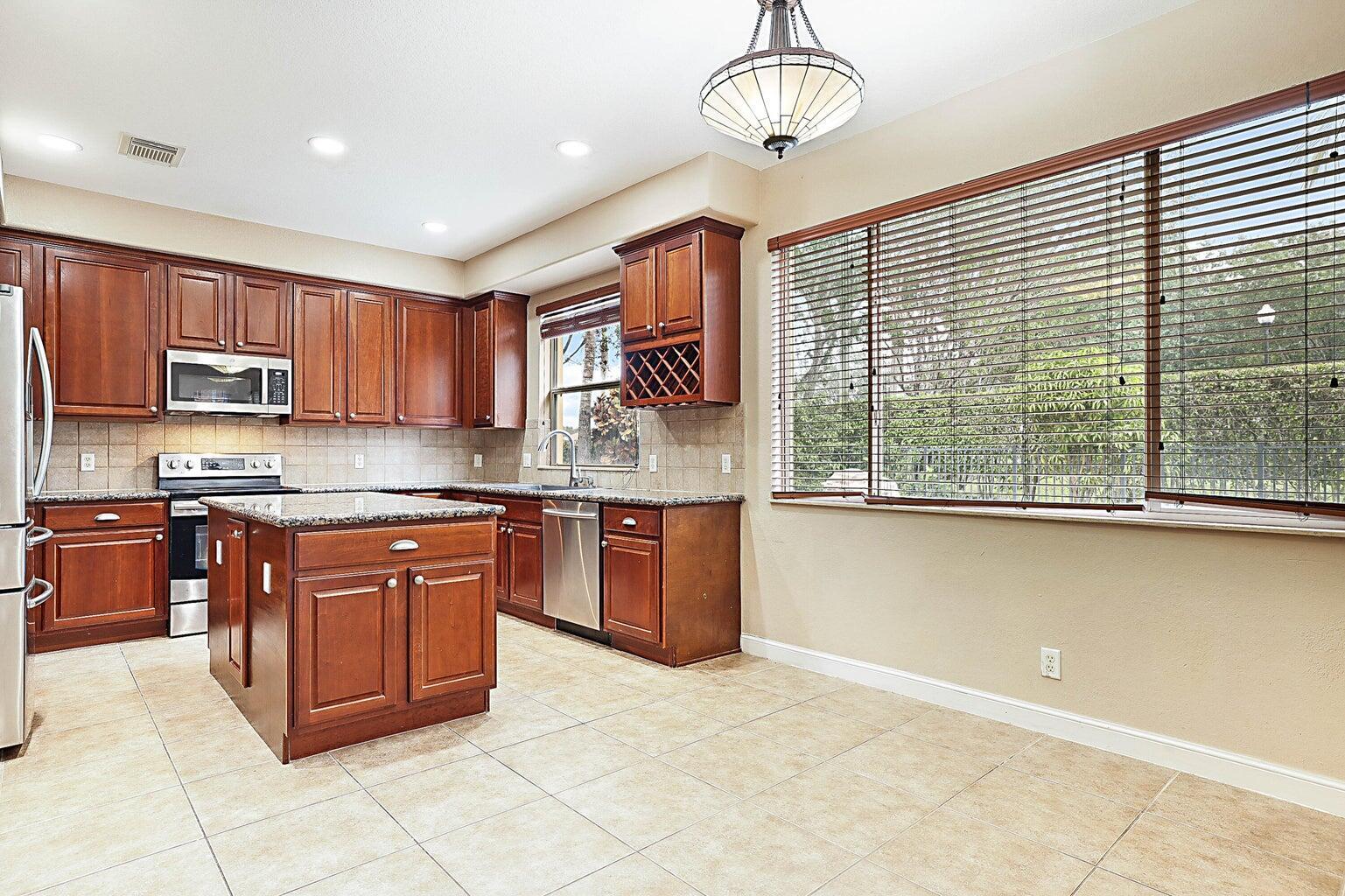 748 Cresta Circle West Palm Beach, FL 33413 - Photo 23 of 62 a large kitchen with stainless steel appliances granite countertop a stove sink and cabinets