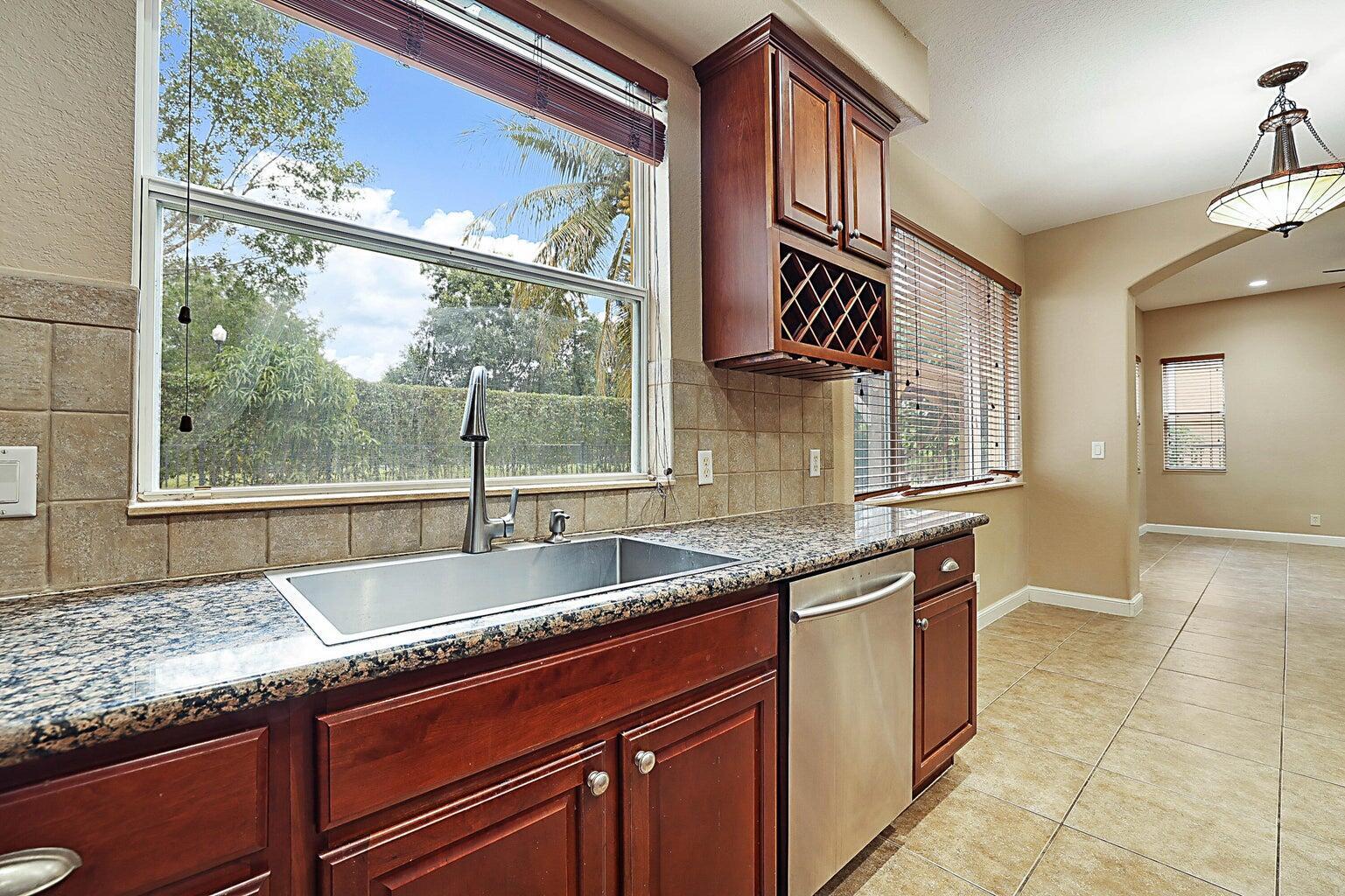 748 Cresta Circle West Palm Beach, FL 33413 - Photo 24 of 62 a kitchen with granite countertop a sink and a window