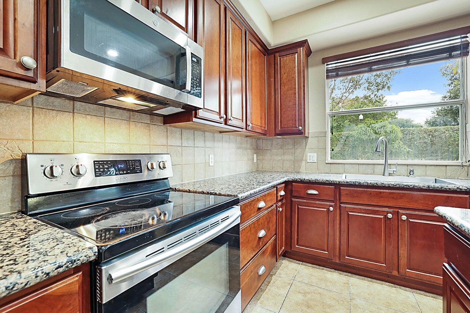 748 Cresta Circle West Palm Beach, FL 33413 - Photo 27 of 62 a kitchen with a stove a sink and a microwave