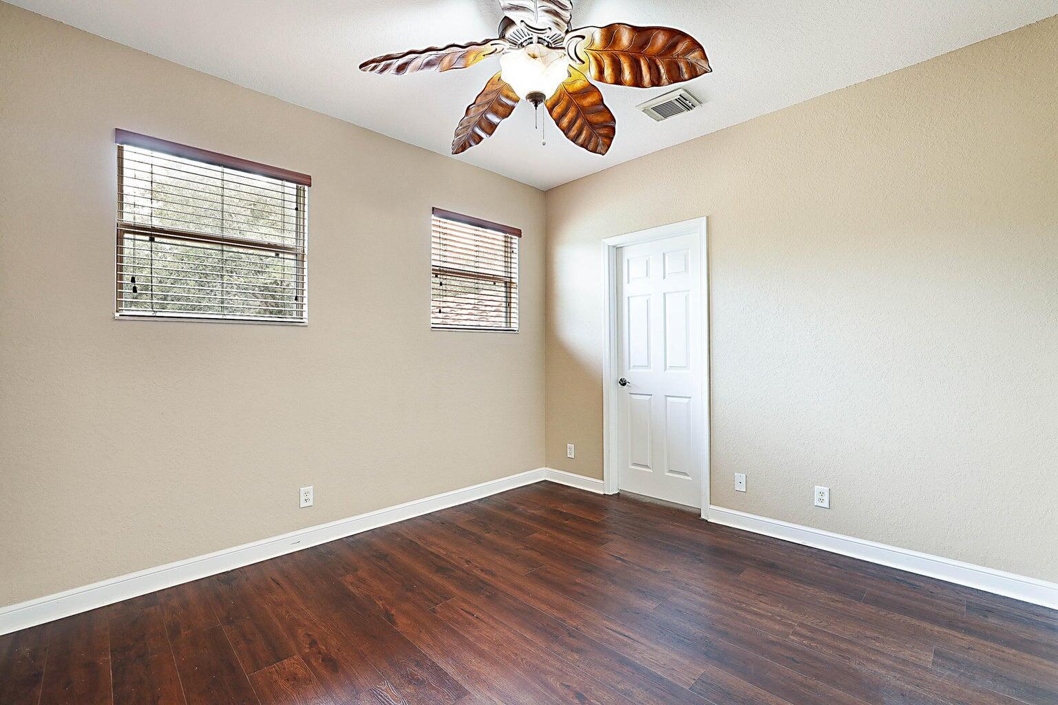 748 Cresta Circle West Palm Beach, FL 33413 - Photo 36 of 62 an empty room with wooden floor and windows