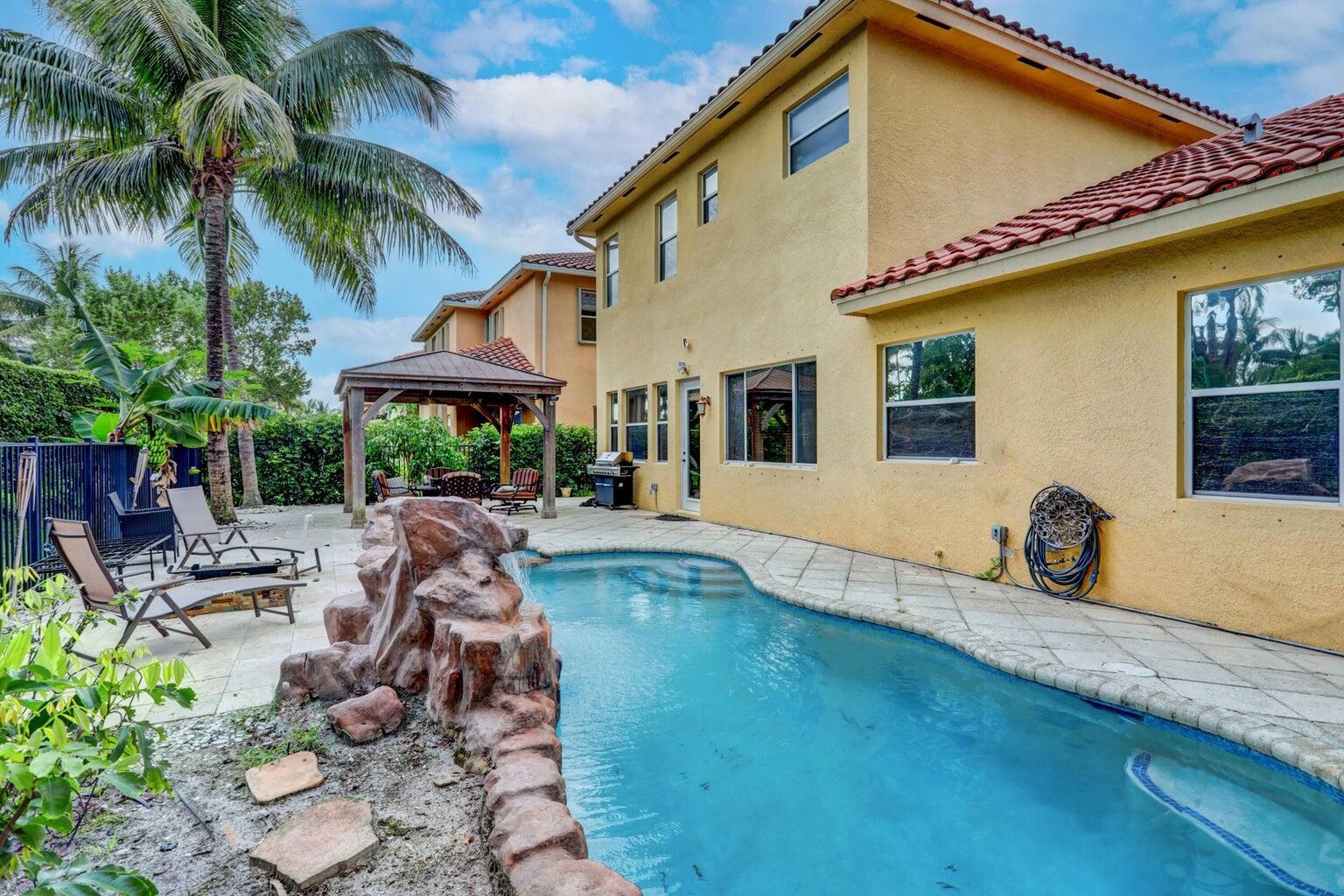 748 Cresta Circle West Palm Beach, FL 33413 - Photo 51 of 62 a view of a patio with table and chairs potted plants and palm tree